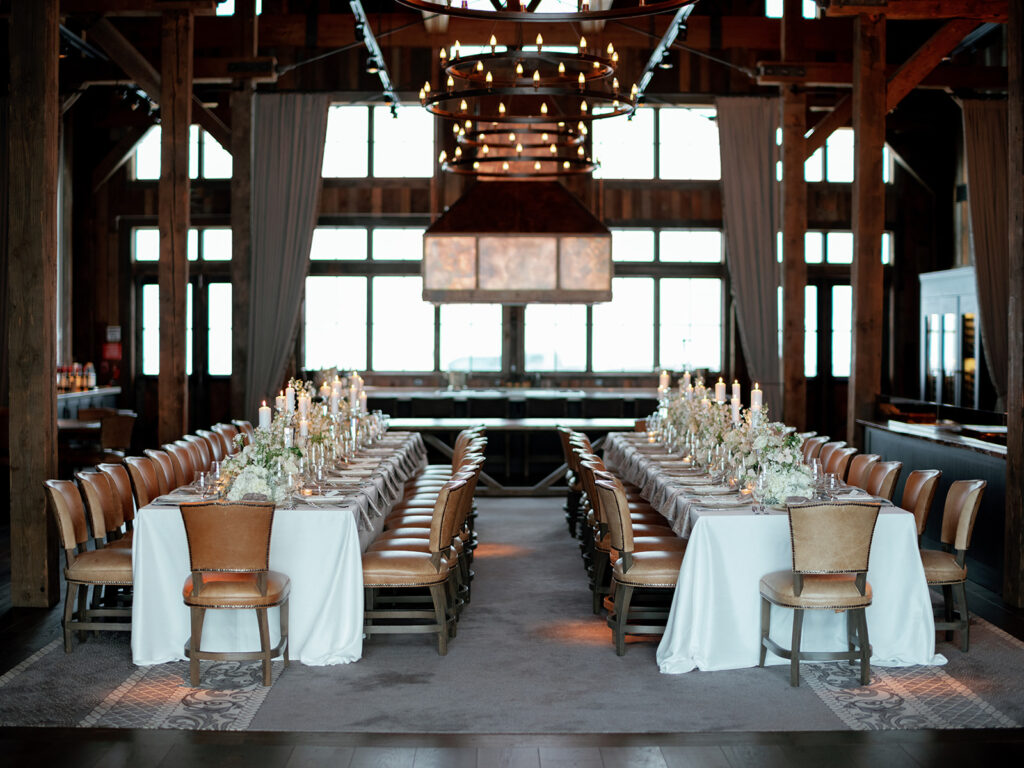 Wedding reception table decor featuring crystal glassware, custom menus, and a neutral color palate at Brush Creek Ranch.