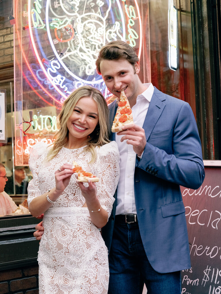 A couple enjoying a slice of pizza during their New York City engagement session.